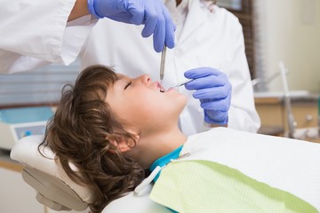 Naklejka na ściany i meble Pediatric dentist examining a little boys teeth