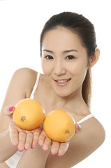 Obraz na płótnie Canvas Portrait of beautiful woman, she holding fresh orange