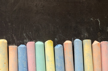 Colorful chalks on blackboard