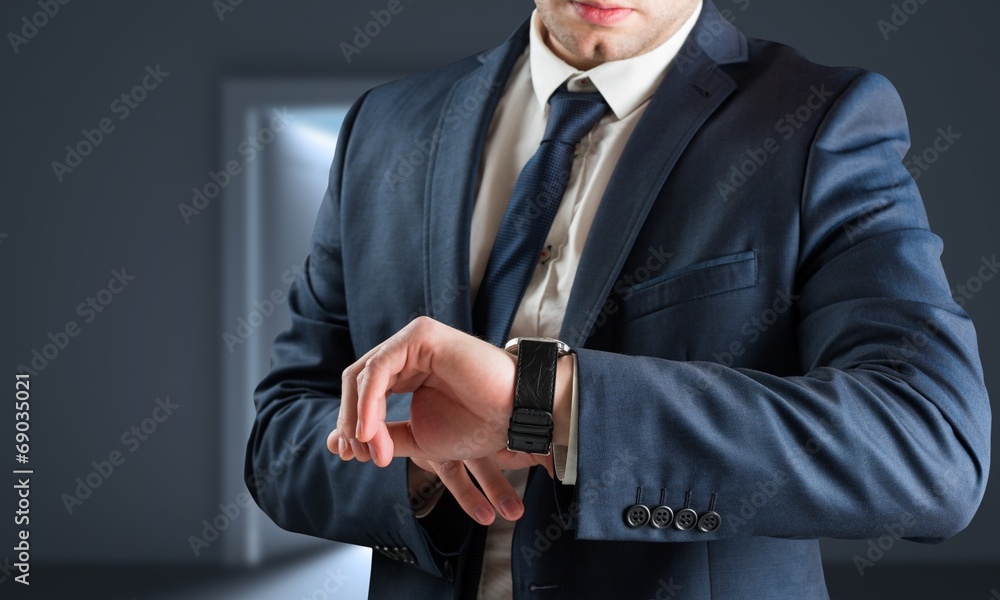 Poster Composite image of businessman checking the time on watch