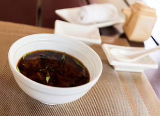 Miso soup in a white bowl.