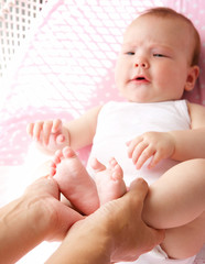 Mother holding cute baby feet