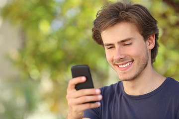 Fototapeta na wymiar Happy man using a smart phone outdoor