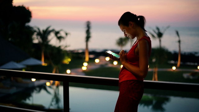 Young woman watch photos on smartphone on terrace at night