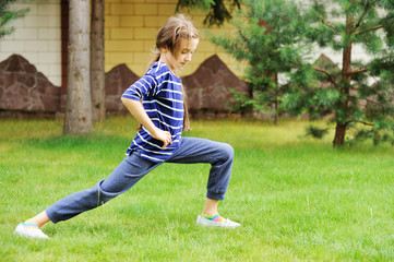 Fototapeta premium Adorable preteen girl doing exercise outdoors