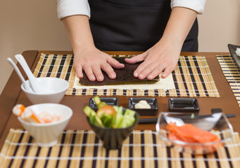 Woman chef ready to prepare japanese sushi rolls