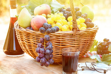 Autumn harvest in wicker basket and red wine