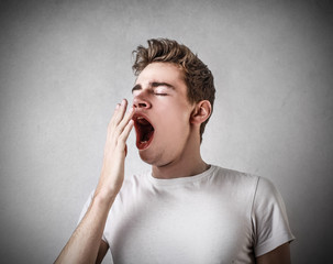 sleepy young boy yawning