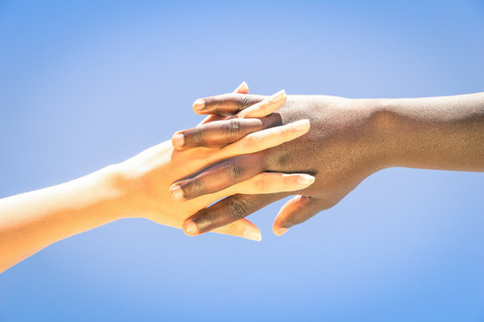 Interracial human hands crossing fingers for friendship and love