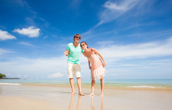 front view of happy young couple at tropical beach