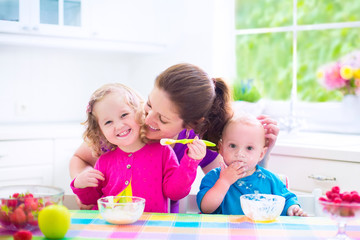Obraz na płótnie Canvas Happy mother and kids having breakfast