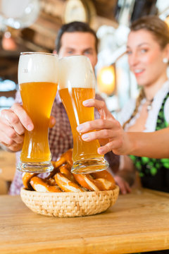 Bayrisches Paar stößt mit Bier an