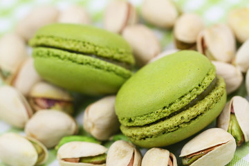 Pistachio macaroons on pistachio nuts, close up