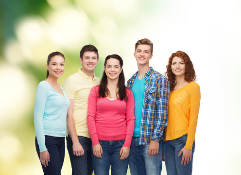 group of smiling teenagers over green background