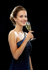 smiling woman holding glass of sparkling wine