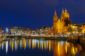 Naklejka premium Night city view of Amsterdam canal and Basilica of Saint Nichola