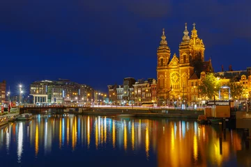  Nacht uitzicht op de stad van de Amsterdamse gracht en de Sint-Nicolaasbasiliek © Kavalenkava