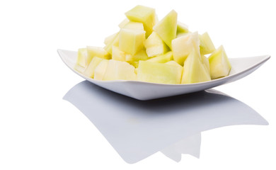 Bite sized honeydew pieces on white plate