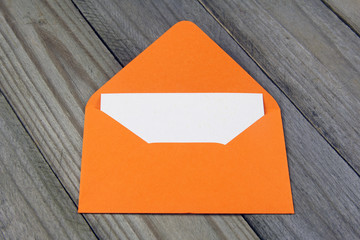 orange open enveloped with blank card on wooden background