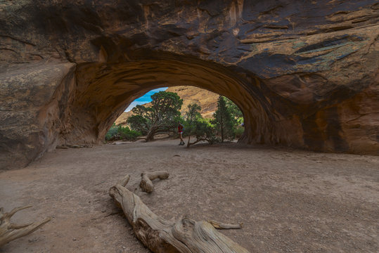Famel hiker stading in Navajo Arch at beautiful summer day  near