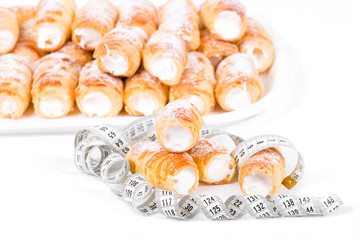 concept of slimming, cakes with measuring tape