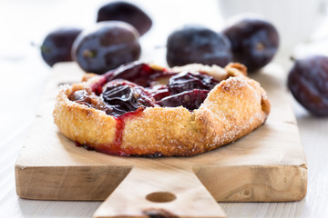 Homemade plum galette on wooden board
