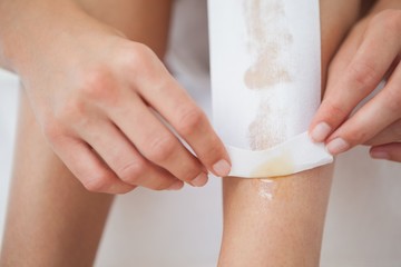 Woman waxing her legs herself