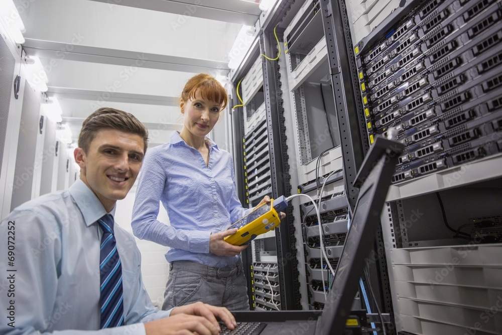 Aufkleber team of technicians using digital cable analyser on servers