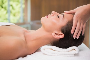 Obraz na płótnie Canvas Attractive woman receiving head massage at spa center