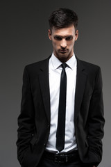 Handsome young man on grey background.