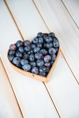 fresh blueberries in heart shape basket on kitchen table