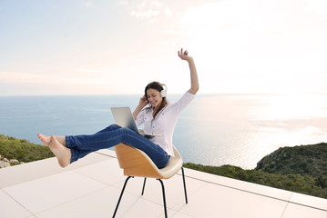 relaxed young woman at home working on laptop