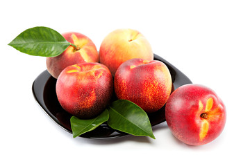 Fresh fruit nectarines and peaches with green leaves.