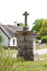 old stone cross in village de Breca, France