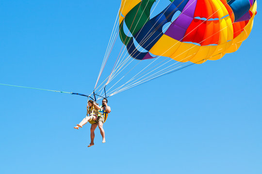 people parakiting on parachute in blue sky