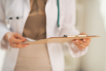 Closeup on doctor woman holding clipboard