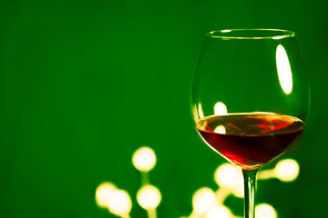 Red wine in glass.Green background.Christmas gift card.
