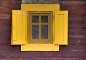 Obraz na płótnie Canvas Yellow window on wooden wall