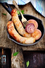 Roasted beef sausages at frying pan
