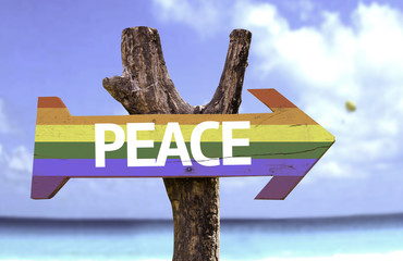 Peace in a Rainbow wooden sign with a beach on background