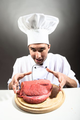 Funny chef with a piece of raw meat