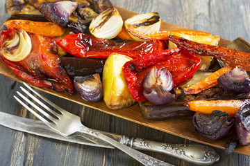 Roasted vegetables, fork and knife.