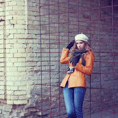 girl with an old camera walks through the streets