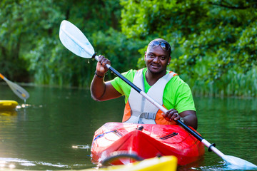 Afrikanischer Mann fährt im Kajak auf Wald Fluss 