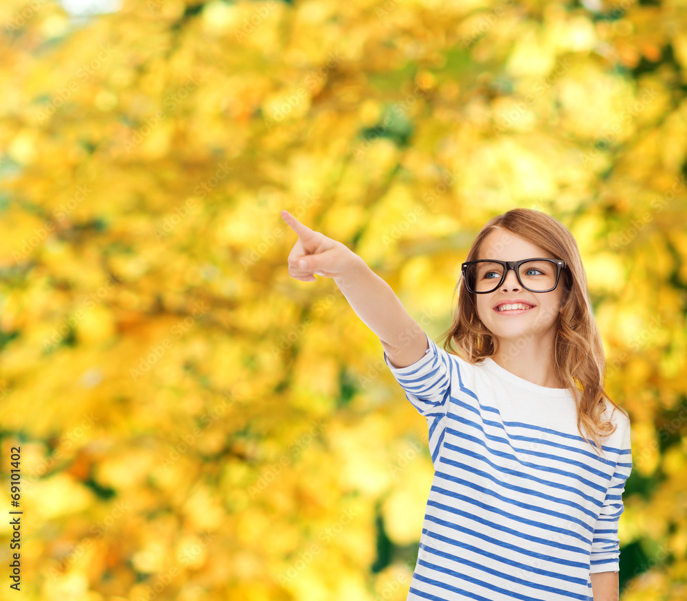 Poster cute little girl in eyeglasses pointing in the air