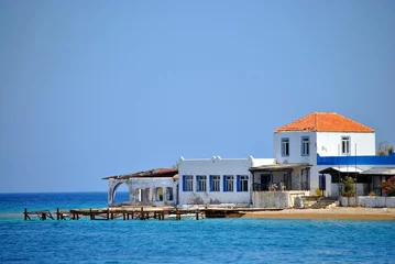 Fotobehang oud vervallen hotel bij de zee © trinetuzun