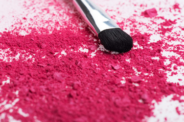 Close-up of  professional  make-up brush with crashed pink eye s