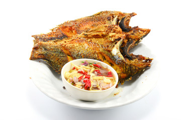 fried nile tilapia fish with mango sauce on white plate isolate 