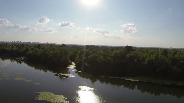 Evening  flight over  river with sun on sky . Aerial view