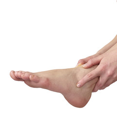 Acute pain in ankle. Woman holding hand to spot of ankle-aches.